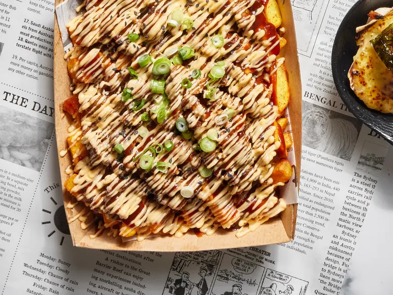 Peking duck chips with chilli mayonnaise, black sesame and spring onion in a takeaway box