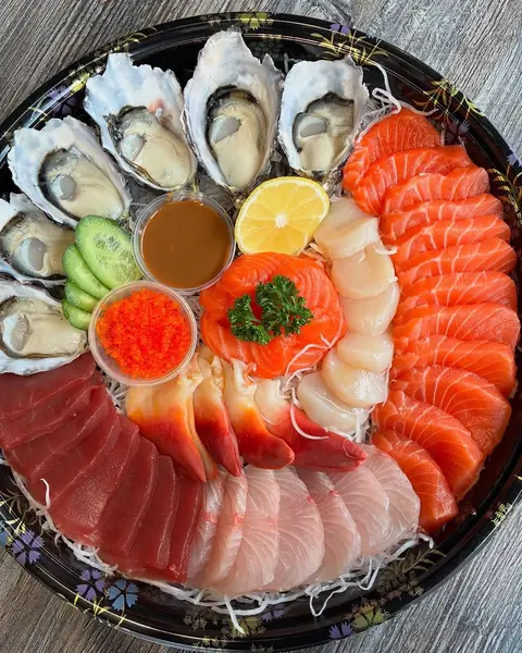 A round platter of oysters, salmon, tuna and kingfish sashimi with sauces