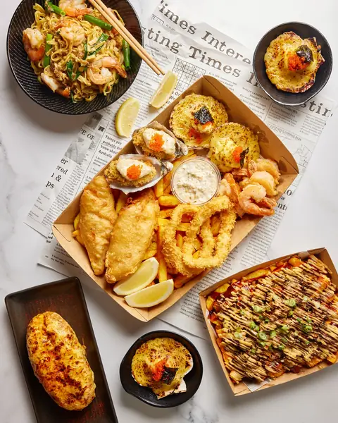 Battered fish, calamari, fried rice and a lobster roll in paper-lined boats
