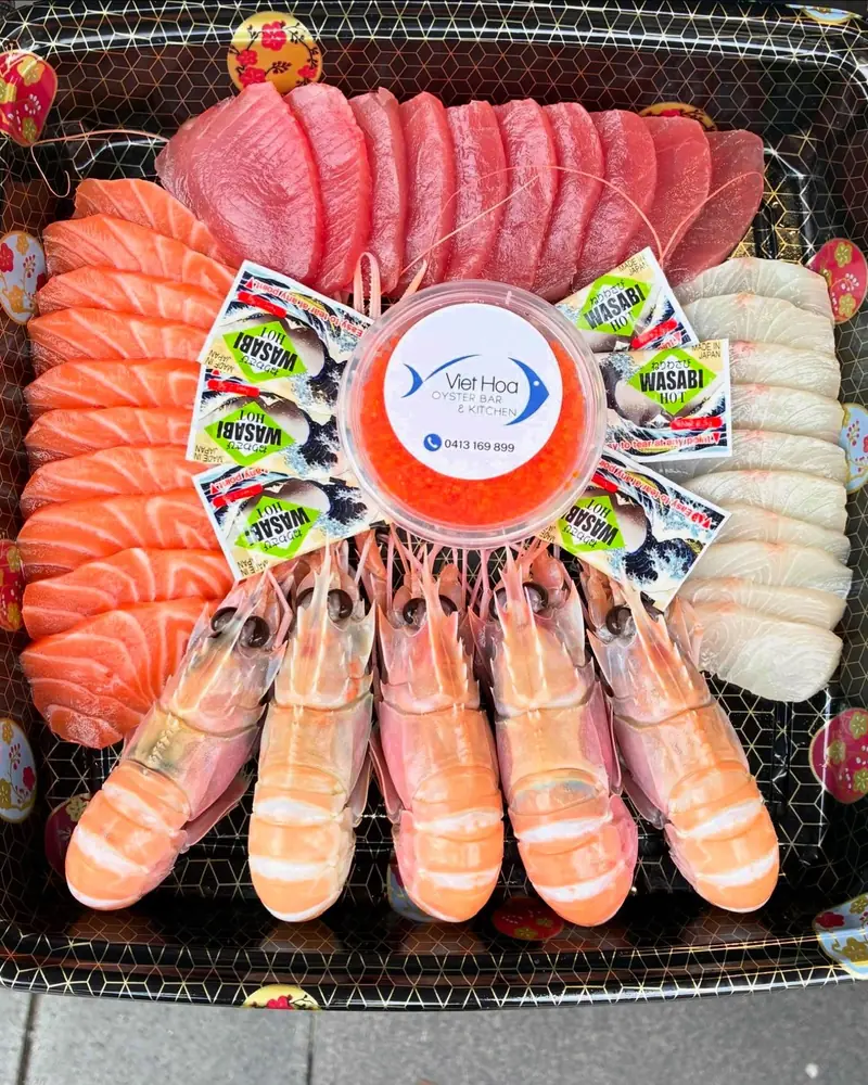 A round sashimi platter of salmon, tuna and kingfish with king prawns, made to order